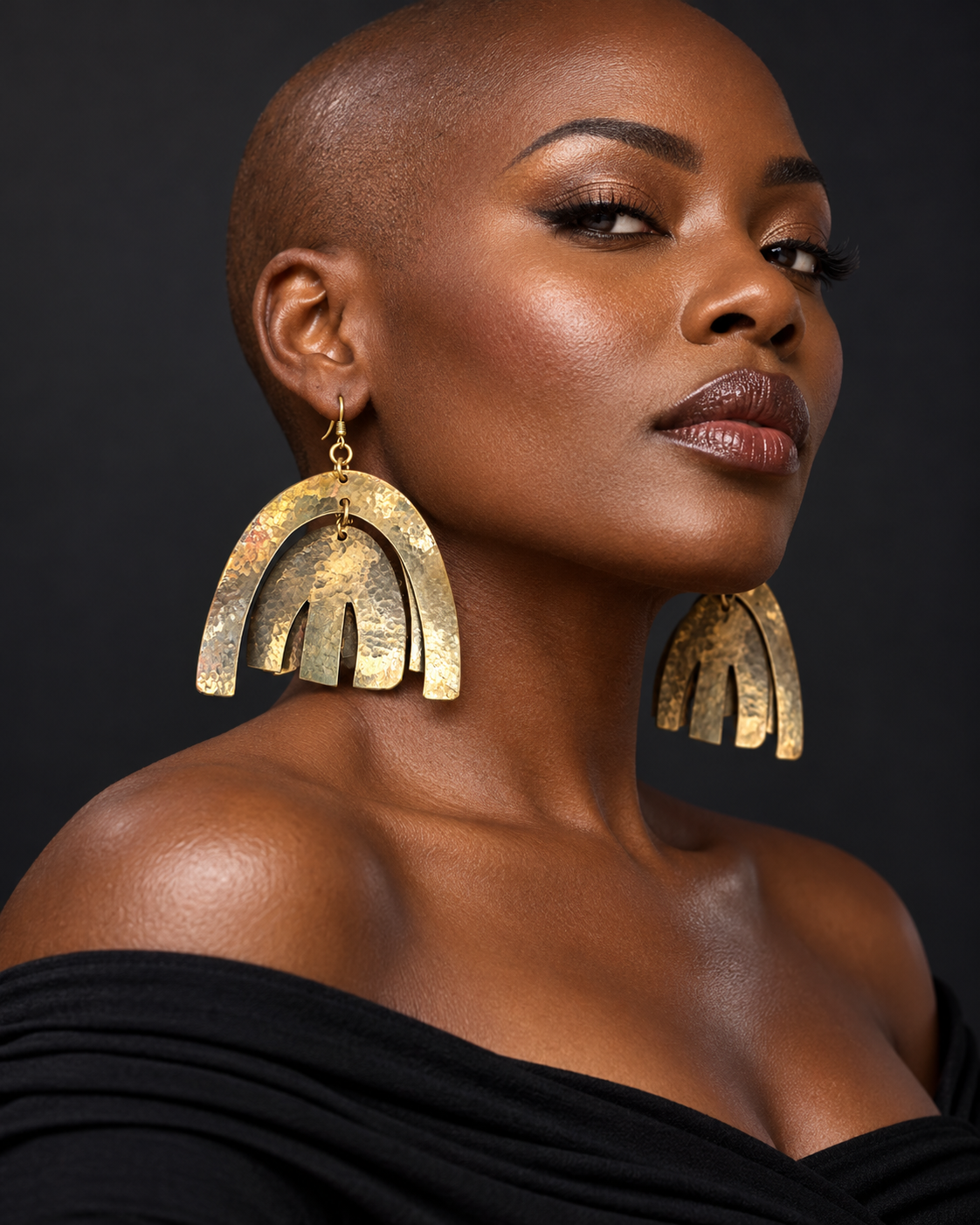 AI styling visualization — AATC brass curve drop earrings on a bald Black woman; see original photo for product details.